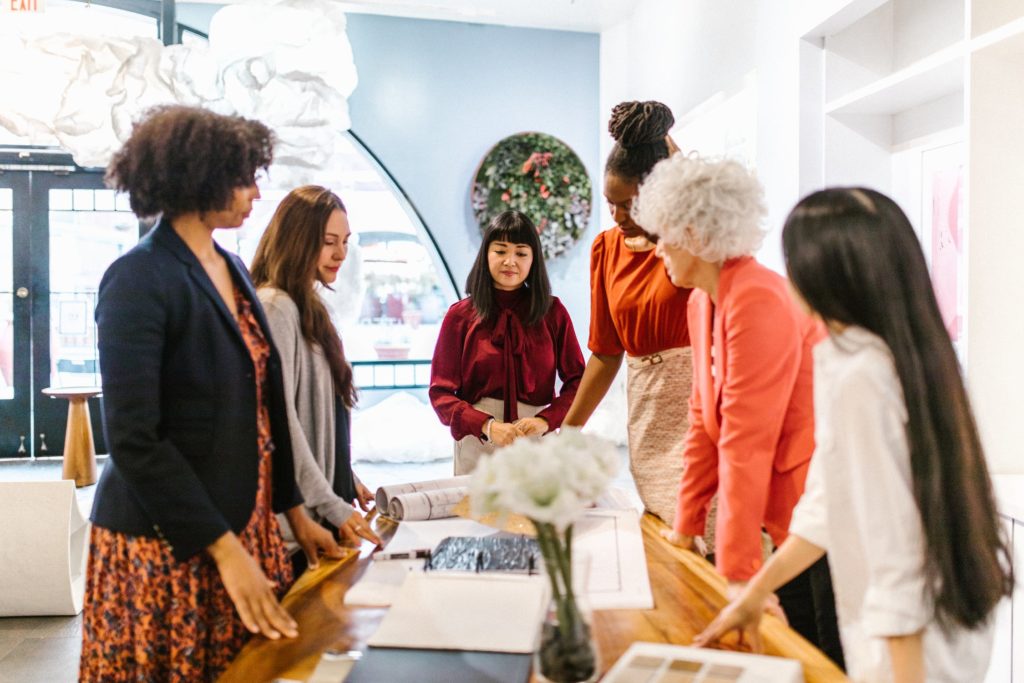 a group of women standing around a table