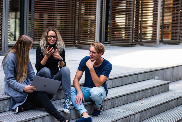 a group of people sitting on a bench outside