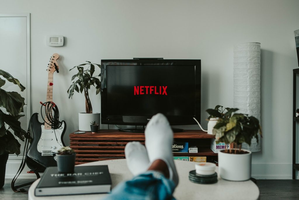 a person's feet on a desk in front of a tv