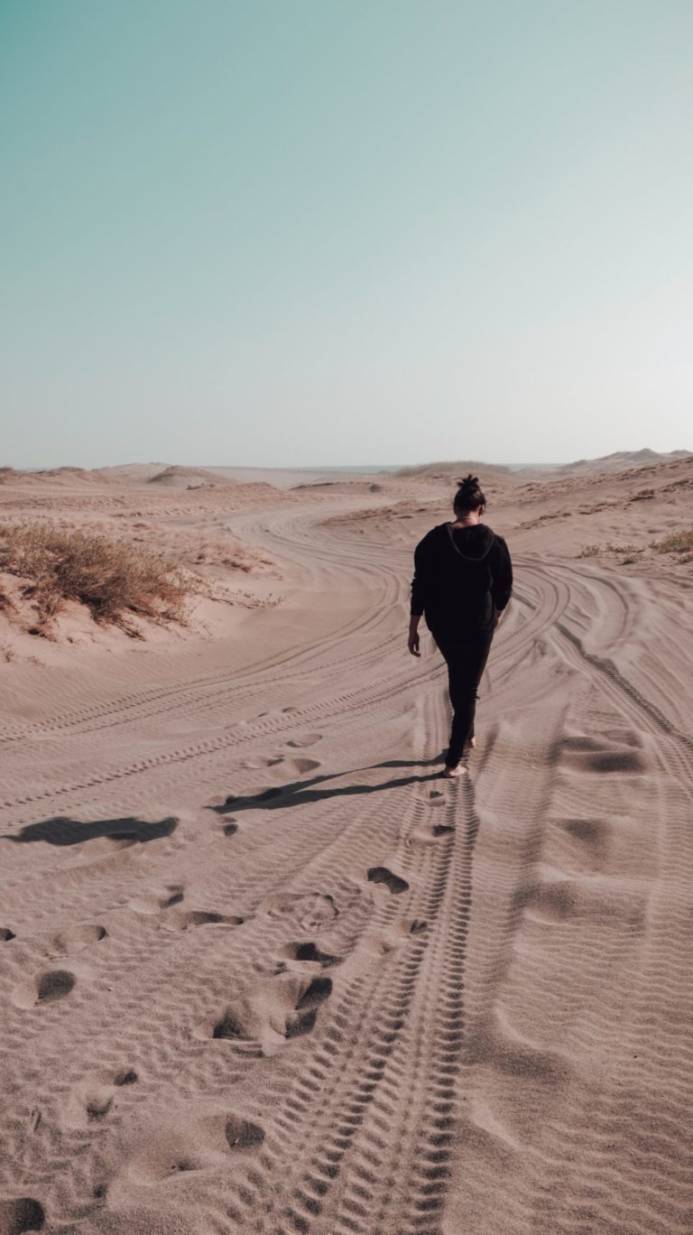 a person walking on a sandy road