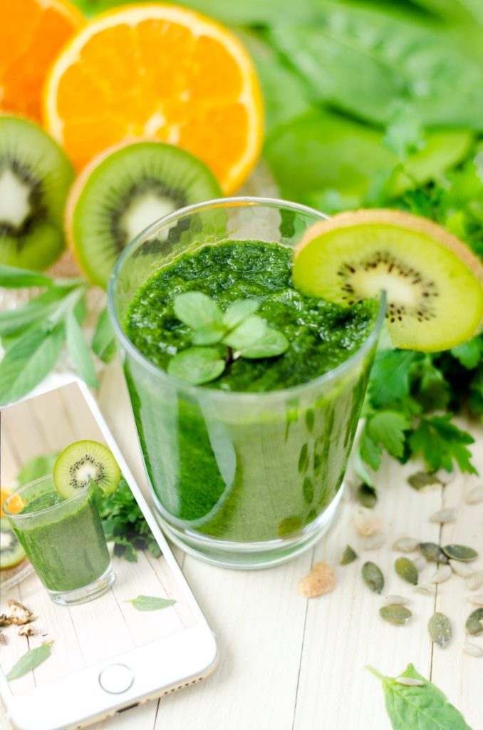 a bowl of green liquid with limes in it