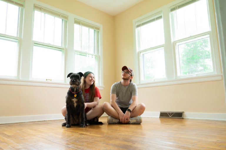 a person and a dog sitting on the floor in a room
