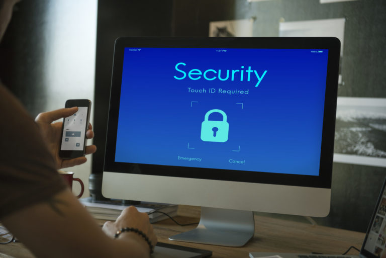 a person holding a phone in front of a computer screen